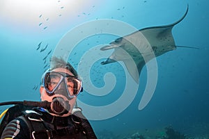 Scuba diver and Manta in the blue ocean background portrait