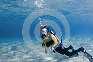 Scuba diver over white sand