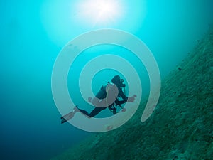 Scuba diver passing as bubble rising.