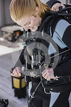 Scuba diver putting her BCD on