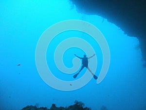 Scuba diver at underwater cave exit