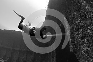 Scuba diver underwater with shipwreck photo