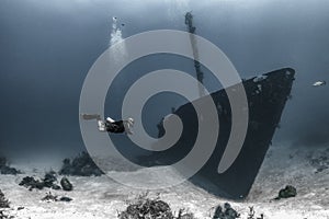 Scuba diver underwater with shipwreck photo