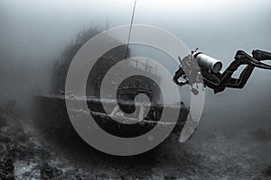 Scuba diver underwater with shipwreck photo