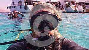 Scuba diver woman making selfie in the water after diving