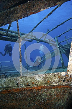 Scuba divers explore a shipwreck underwater