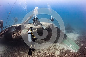 SCUBA divers explore the wreck of an aircraft