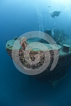 Scuba divers exploring the bow of a shipwreck. Re