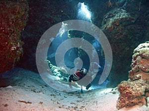 SCUBA Divers Swim Through Coral Tunnels