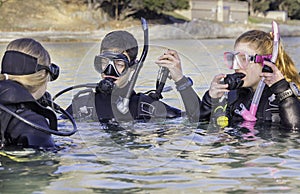 Scuba divers training in the sea looking at their instructor