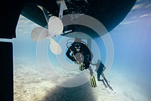 Scuba divers under ship keel