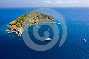 SCUBA diving boats and diver around a rugged, remote tropical island Koh Bon island, Similan Islands, Thailand