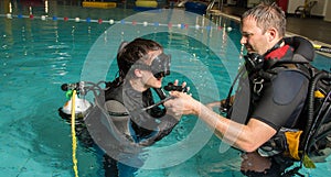 Scuba diving course pool teenager girl with instructor in the water