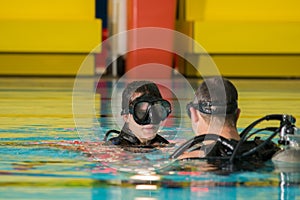 Scuba diving course pool teenager girl with instructor in the water