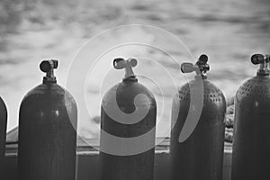 Scuba diving extreme sport on blue water background Oxygen compressed air in black steel bottles