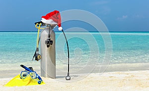 Scuba diving gear on tropical beach with a christmas hat