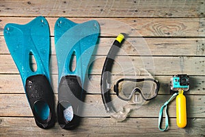 Scuba mask, snorkel and blue flippers with sports camcorder.