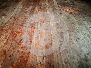 Scuffed dirty hardwood floor, showing red stains resembling blood - abandoned house, scary horror scene background