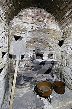 Scullery with stoneware dishes, shovel and fireplace