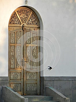 The sculpted door of a church and a row in flight