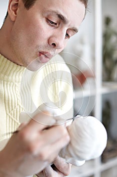 Sculptor carefully works on plaster statuette