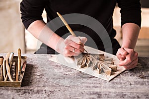 The sculptor creates a bas-relief. Plaster workshop. Close up. Selective focus