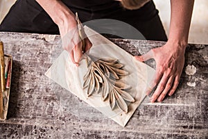 The sculptor creates a bas-relief. Plaster workshop. Close up. Selective focus