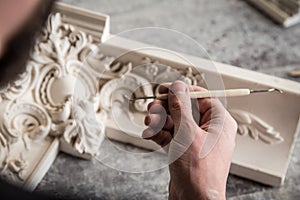 The sculptor creates a bas-relief. Plaster workshop. Close up. Selective focus