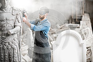 Sculptor grinding sculpture in the studio