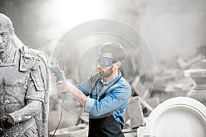 Sculptor grinding sculpture in the studio photo