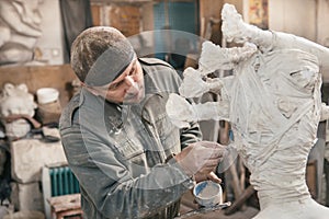 Sculptor man working in his workshop