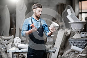 Sculptor with a piece of stone in the studio