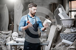 Sculptor with a piece of stone in the studio photo