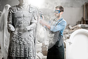 Sculptor grinding sculpture in the studio photo
