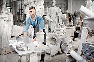 Sculptor working with laptop in the studio