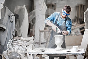 Sculptor working with sculptures in the studio