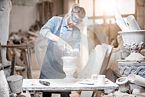 Sculptor working with sculptures in the studio