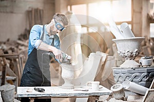 Sculptor working with sculptures in the studio