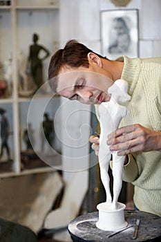 Sculptor works attentively in studio