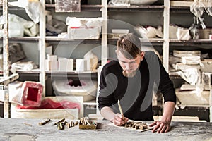 Sculptor works with concentration in the studio on a fragment of plaster sculpture. Abstract blur