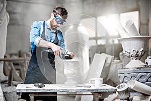 Sculptor working with sculptures in the studio photo