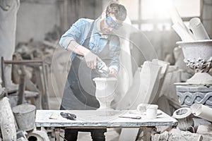 Sculptor working with sculptures in the studio photo
