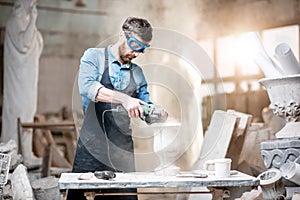 Sculptor working with sculptures in the studio photo