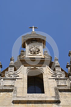 Sculptural facade with a cross and a coat of arms