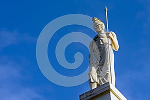 Sculpture and ancient Greek warrior with a spear against the sky.