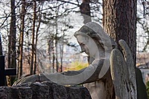 Sculpture of an angel made of stone on a grave in a cemetery