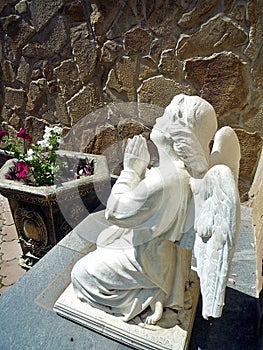 Sculpture of angel in prayer on a garden photo
