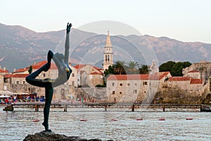 Sculpture Ballerina (Dancer of Budva) against backdrop of old town