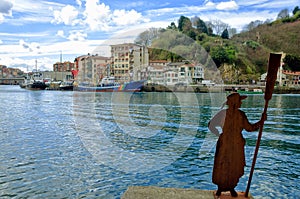 Sculpture in bay with view of the town of Donibane, Spain