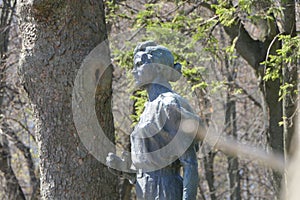 A sculpture of a beautiful, slender female figure surrounded by trees.